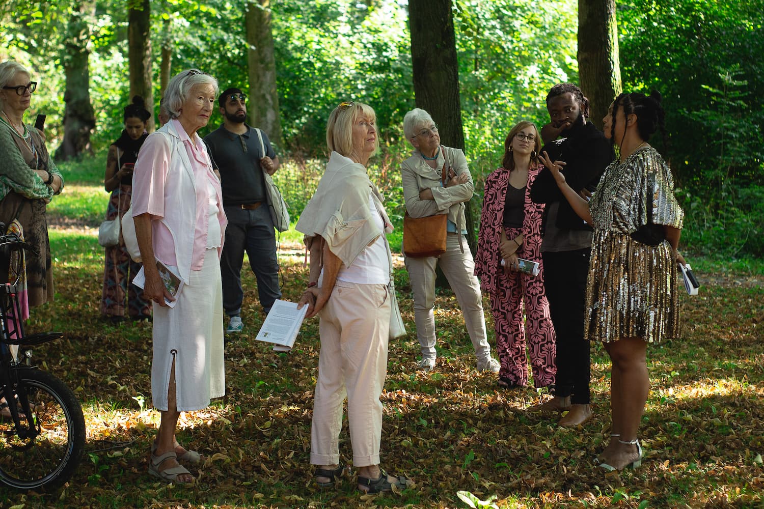 a group of people stand in a circle and talk in Lantz'scher Park